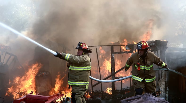 Firefighters from three local departments battled a fire that involved six mobile homes Wednesday, Sept. 20, 2023, on Marquart Road at Ohio 235 in Pike Twp., Clark County. BILL LACKEY/STAFF