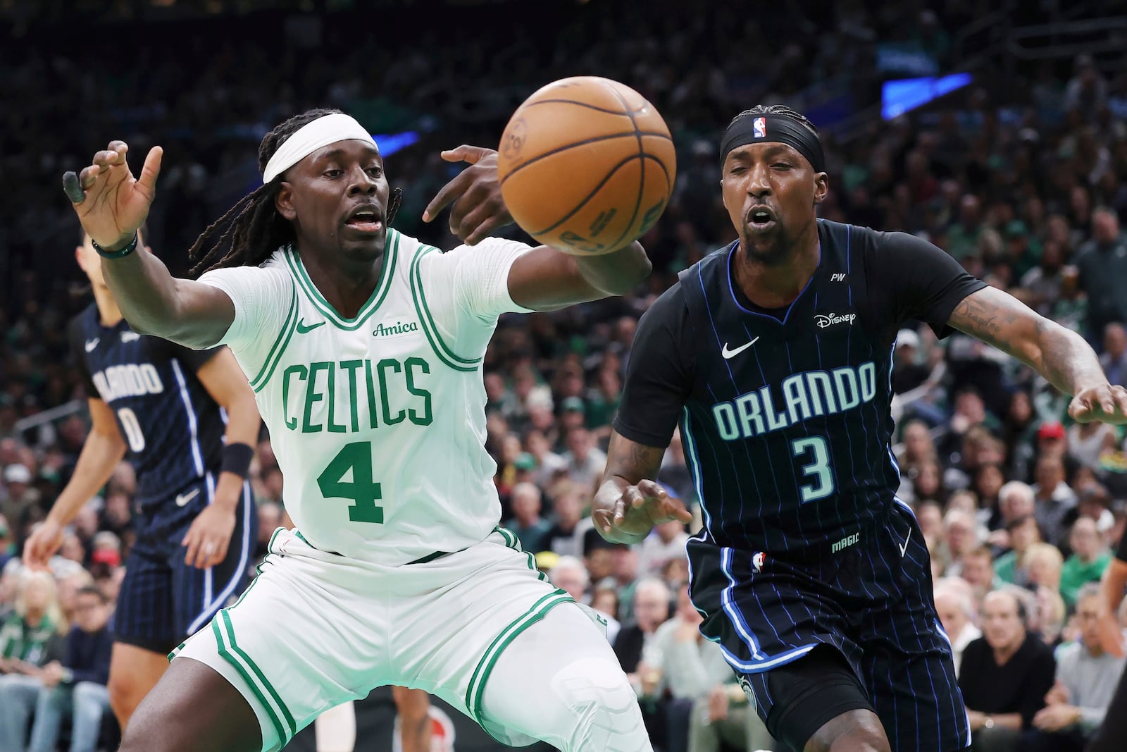 Boston Celtics' Jrue Holiday (4) looses control of the ball against Orlando Magic's Kentavious Caldwell-Pope (3) during the first half in game 1 of a first-round NBA playoff basketball series Sunday, April 20, 2025, in Boston. (AP Photo/Michael Dwyer)