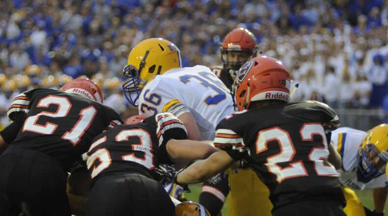 Marion Local running back Alex Partington is met by Coldwater defenders Justin Schwieterman (21), Derek Albers (53) and Ben Wenning (22). Marion Local defeated Coldwater 13-7 in a Week 3 game on Friday, Sept. 8, 2017. MARC PENDLETON / STAFF