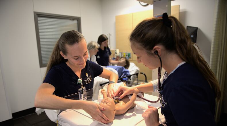 Cedarville University nursing students participate in a simulation with the school’s new mother and baby manikins. Contributed by Cedarville University/Photo by Scott Huck