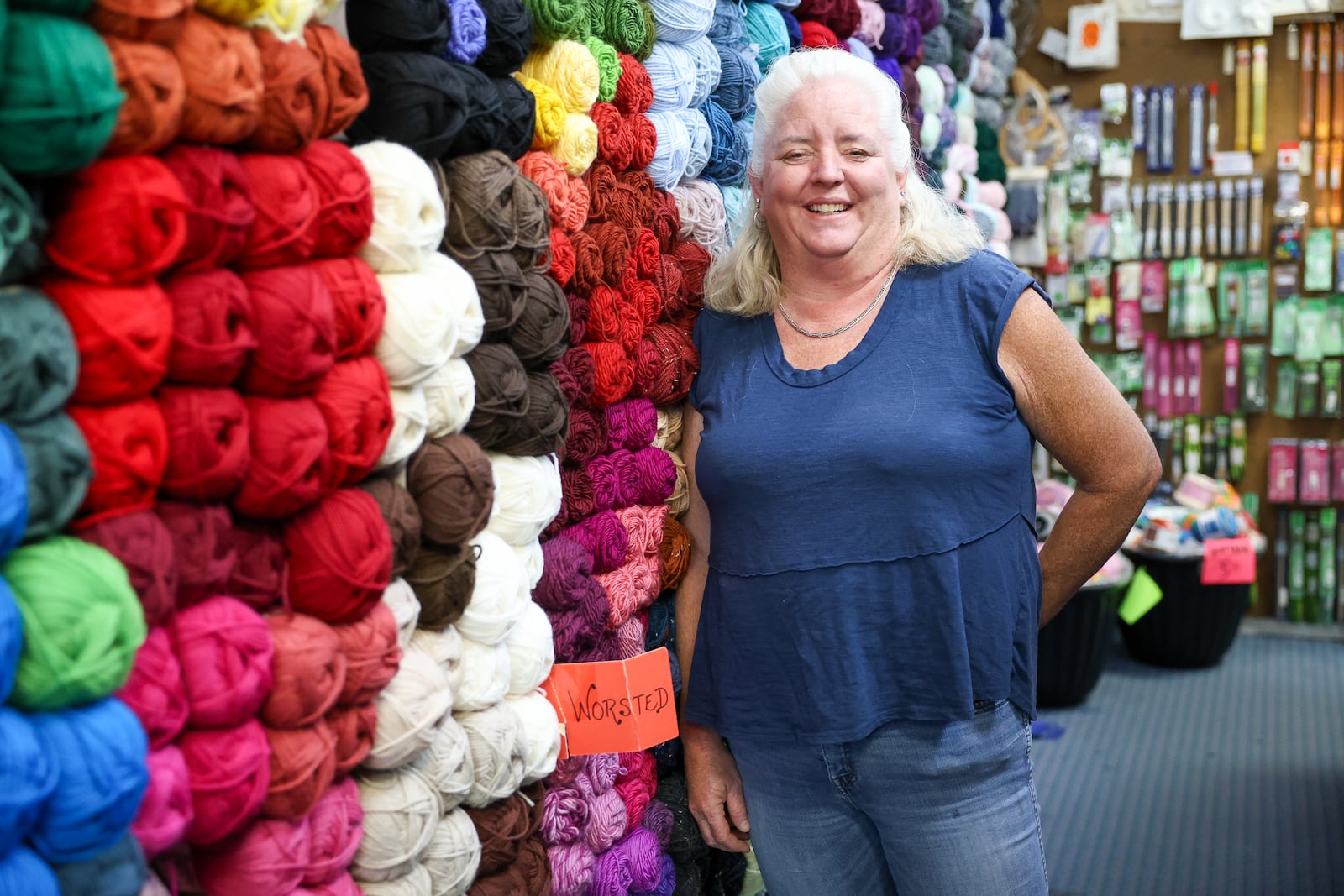 Kathryn Woodruff, who owns Busy Beaver Arts and Crafts in Beavercreek, poses in a aisle with yarn on Thursday, Sept. 4 at the store on Dayton-Xenia Road. The craft store is celebrating its 50th anniversary on Sept. 21. Woodruff's parents opened the shop in 1975. BRYANT BILLING / STAFF