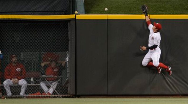 Cincinnati Reds centerfielder Shin-Soo Choo, right, leaps for and misses a home run ball off the bat of St. Louis Cardinals' Carlos Beltran in the fourth inning of a baseball game, Sunday, June 9, 2013, in Cincinnati. (AP Photo/Michael E. Keating)