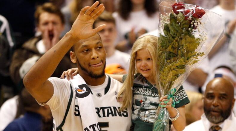 EAST LANSING, MI - FEBRUARY 06: Adreian Payne #5 of the Michigan State Spartans walks on the floor for Senior night with Lacey Holsworth, a 8-year-old from St. Johns Michigan who is battling cancer, after defeating the Iowa Hawkeyes 86-76 at the Jack T. Breslin Student Events Center on February 6, 2014 in East Lansing, Michigan. (Photo by Gregory Shamus/Getty Images)