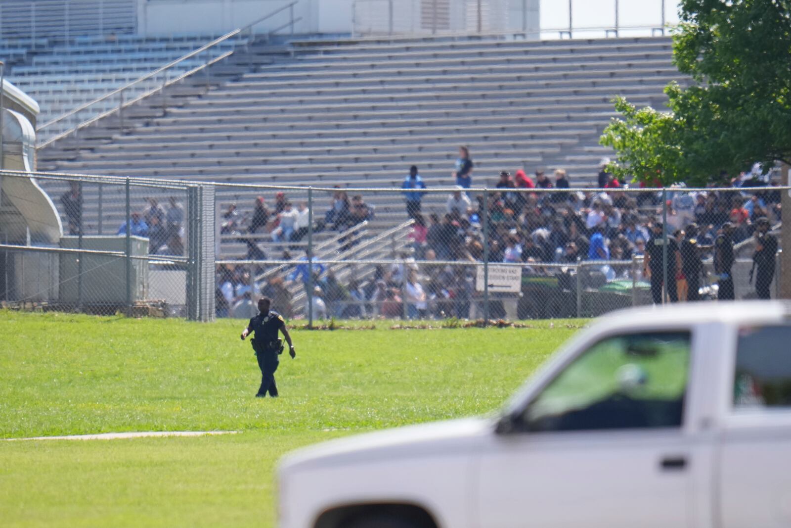 Students sit on stadium bleachers as Wilmer-Hutchins High School, where police are responding to reports of a shooting at in Dallas, Tx., Tuesday, April 15, 2025. (AP Photo/Julio Cortez)