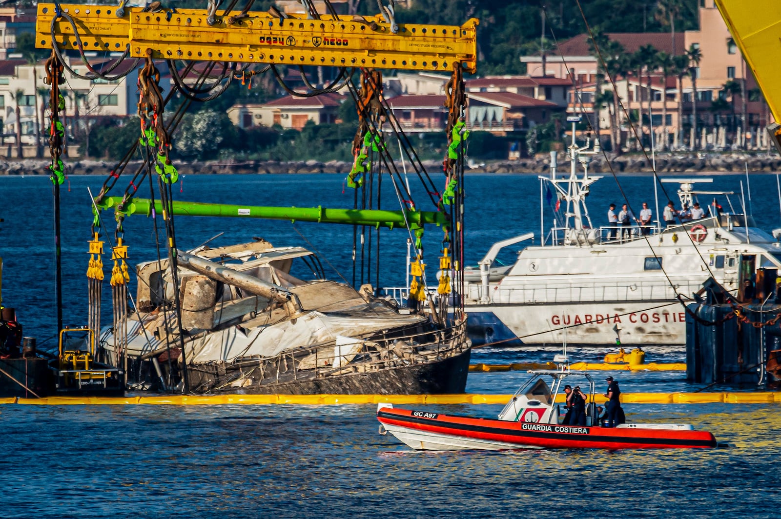 The hull of the superyacht Bayesian, which sank near Palermo, Sicily, on August 19, 2024, is lifted by cranes during salvage operations off the village of Porticello Saturday, June 21, 2025. (AP Photo/Salvatore Cavalli)