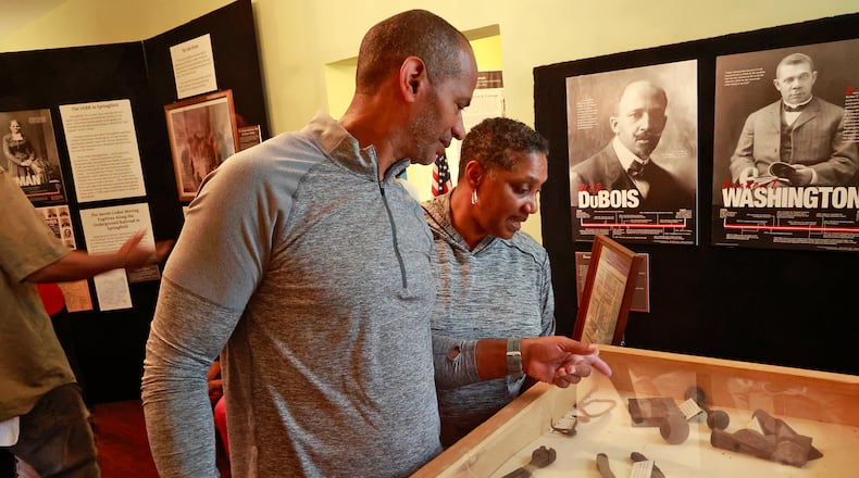 Luke and Kathy McCormick look over some of the items unearthed during the renovation of the Gammon House Saturday, June 17, 2023 during the Juneteenth Celebration in Springfield. BILL LACKEY/STAFF