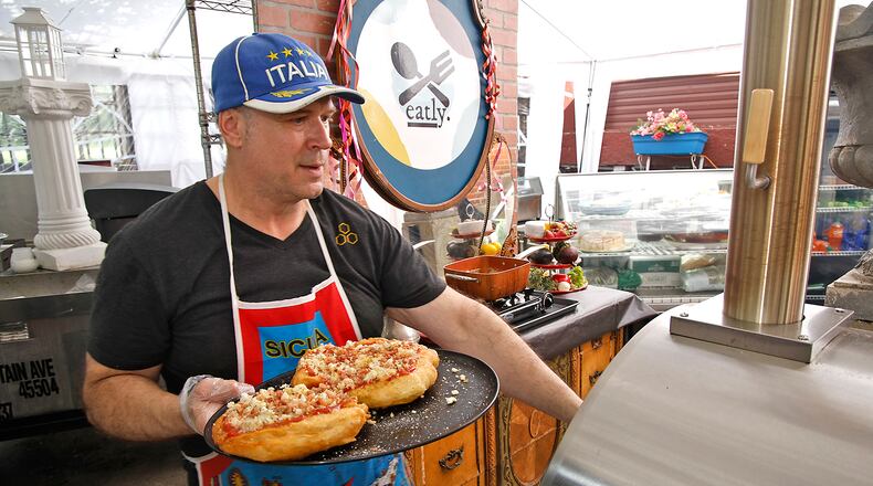 Tom Thompson, owner of Eatly, puts two fig, bacon, onion and gorgonzola fried pizzas in the pizza oven to bake for a few minutes Thursday, May 23, 2024. BILL LACKEY/STAFF