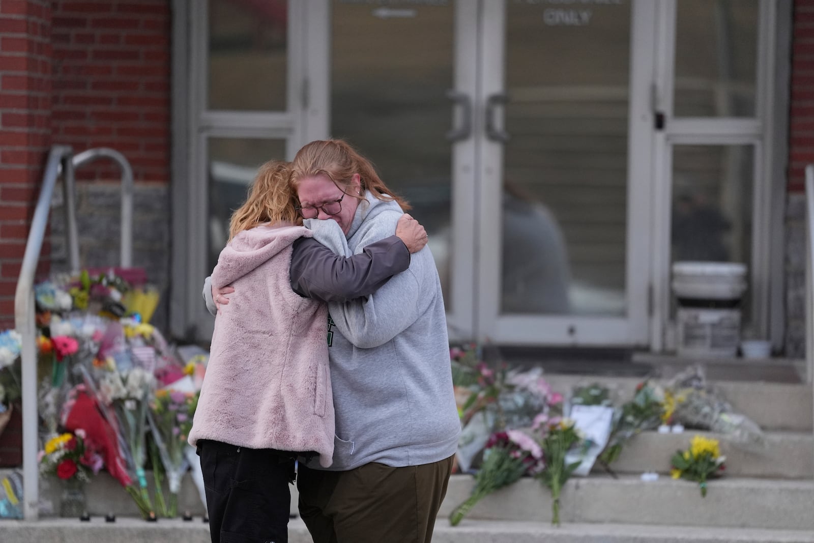 FILE - Leah Fauth gets a hug after leaving flowers in front of the West York Police Department after a police officer was killed responding to a shooting at UPMC Memorial Hospital in York, Pa., Feb. 22, 2025. (AP Photo/Matt Rourke, File)