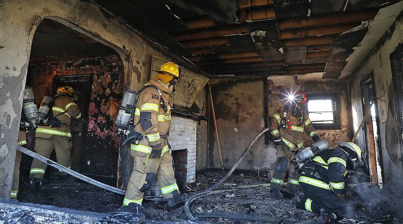 Springfield Township firefighters put out hot spots and look for a cause for the fire that destroyed a two story house at 600 South Bird Road Wednesday morning. BILL LACKEY/STAFF