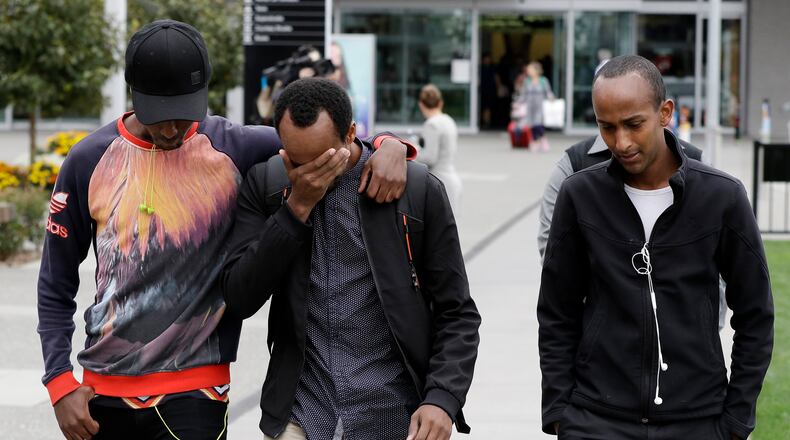Abdifatah Ibrahim, center, and his brother Abdi, right, walk with an unidentified friend in Christchurch, New Zealand, Sunday, March 17, 2019. Abdifatah and Abdi are the older brothers of three-year-old Mucaad, who is the youngest known victim of the mass shooting in Christchurch, New Zealand on Friday, March 15. (AP Photo/Mark Baker)