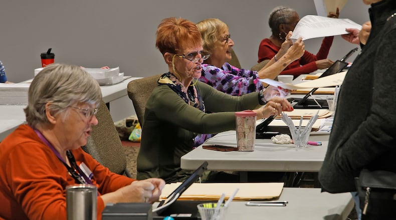 Poll workers check-in voters Tuesday, Nov. 7, 2023 at the First Christian Church in Springfield. BILL LACKEY/STAFF