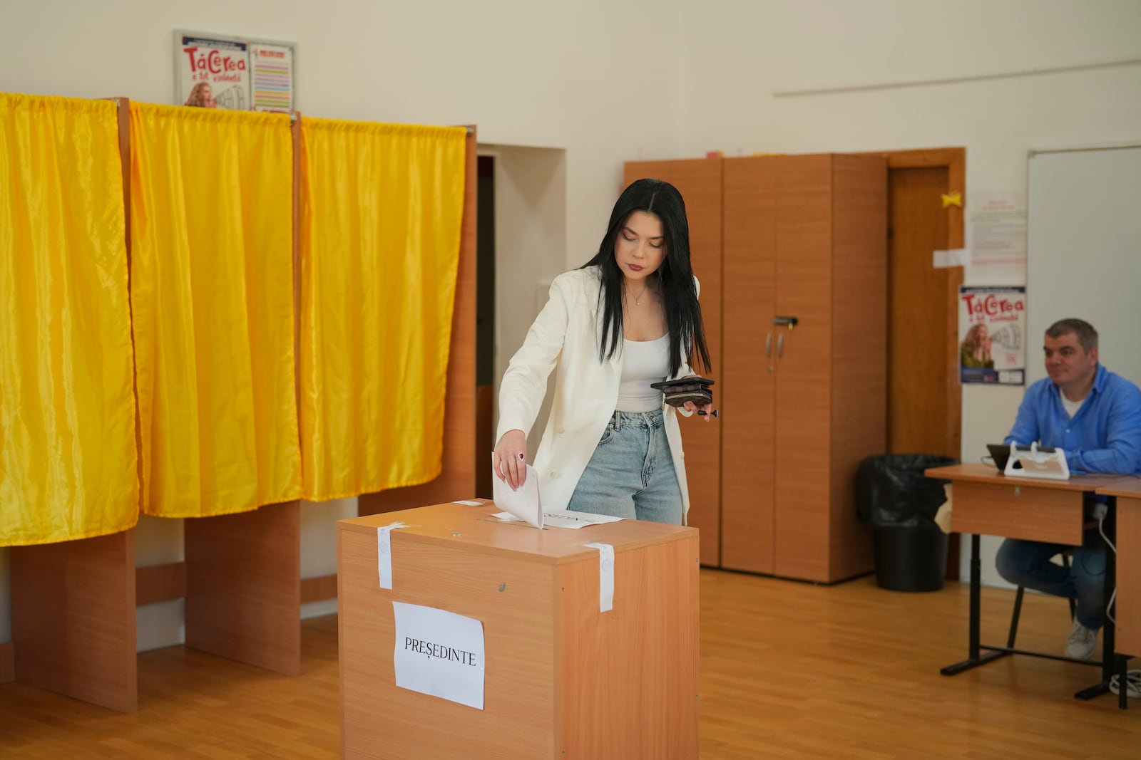 A woman casts her vote in the first round of the presidential election redo in Bucharest, Romania, Sunday, May 4, 2025. (AP Photo/Vadim Ghirda)