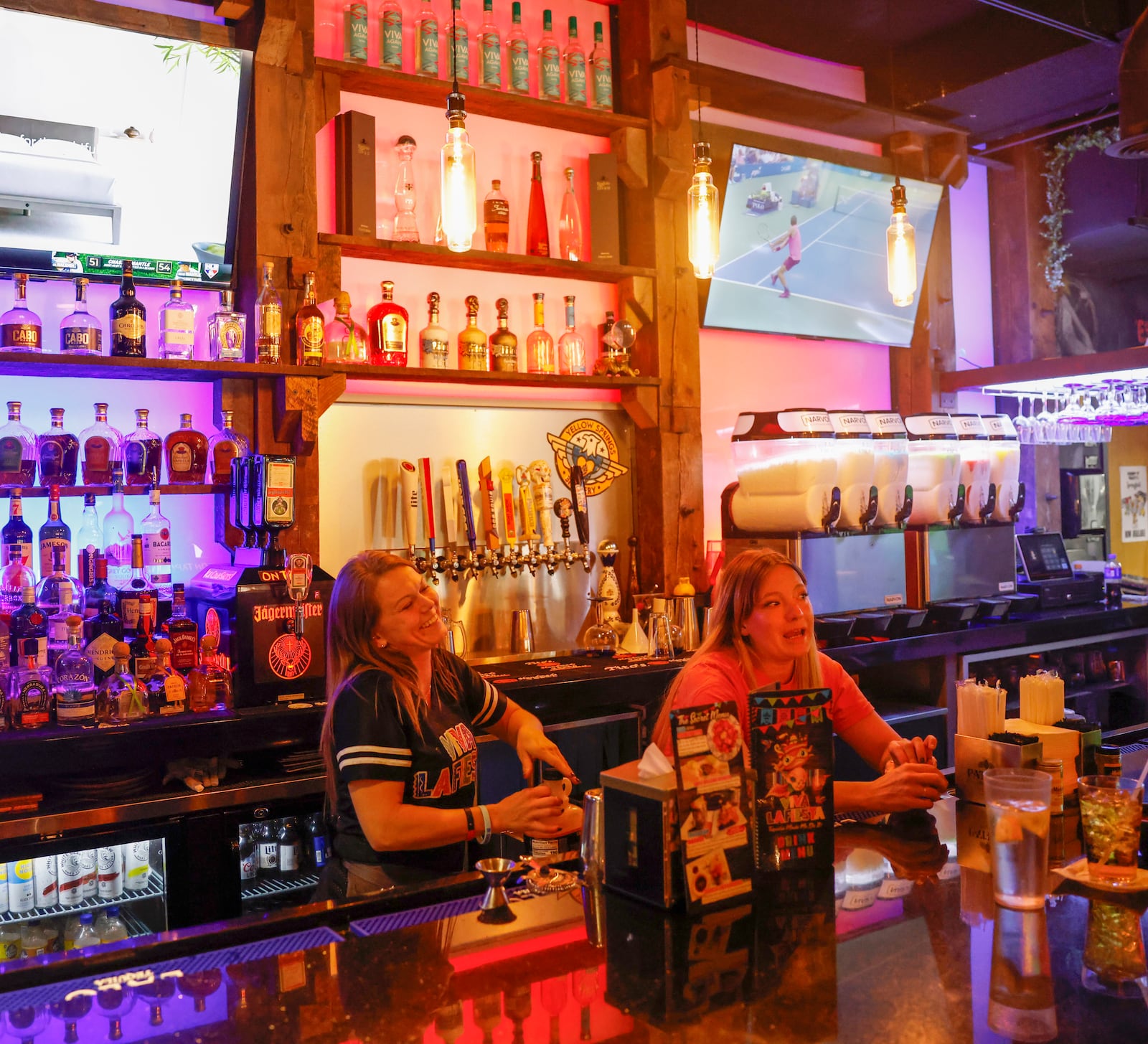 Bartenders Kelly Moore, left, and Lea Elliott socialize with customers at Viva La Fiesta on Friday, September 5, 2025, in Springfield. JOSEPH COOKE/STAFF