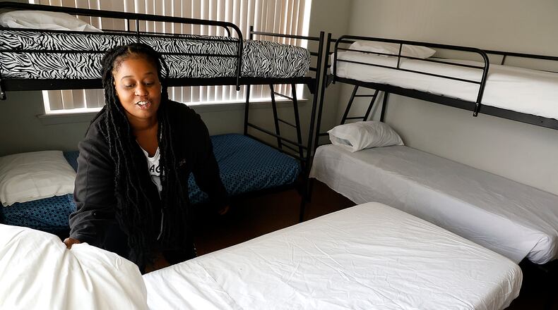 Taylor Cobb makes the beds in one of the family size rooms Tuesday, Sept. 5, 2023 as she helps get Norm's Place homeless shelter ready to reopen. BILL LACKEY/STAFF