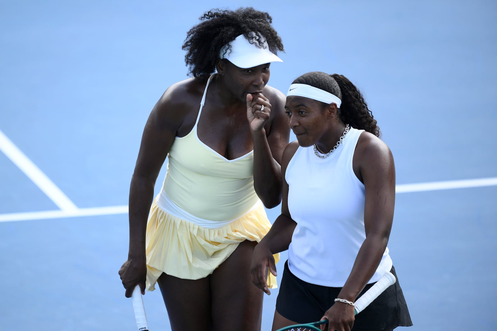 Venus Williams, left, talks with Hailey Baptiste, right, during a doubles match against Eugenie Bouchard and Clervie Ngounoue at the Citi Open tennis tournament Monday, July 21, 2025, in Washington. (AP Photo/Nick Wass)