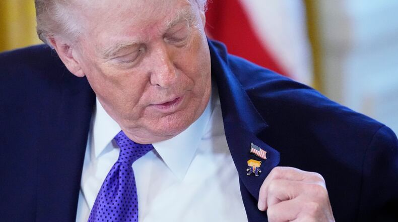 President Donald Trump wears a gift, which he calls a "Happy Trump" pin, during a meeting with oil executives in the East Room of the White House, Friday, Jan. 9, 2026, in Washington. (AP Photo/Alex Brandon)