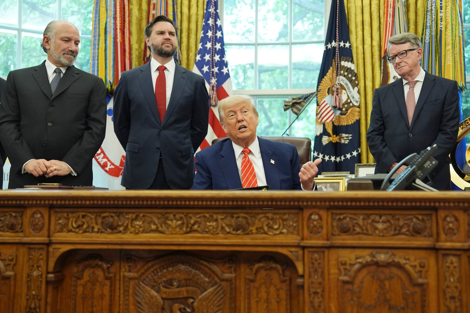 President Donald Trump, center, with from l-r., Commerce Secretary Howard Lutnick, Vice President JD Vance, and Britian's ambassador to the United States Peter Mandelson, making remarks on a trade deal between U.S. and U.K. in the Oval Office of the White House, Thursday, May 8, 2025, in Washington. (AP Photo/Evan Vucci)
