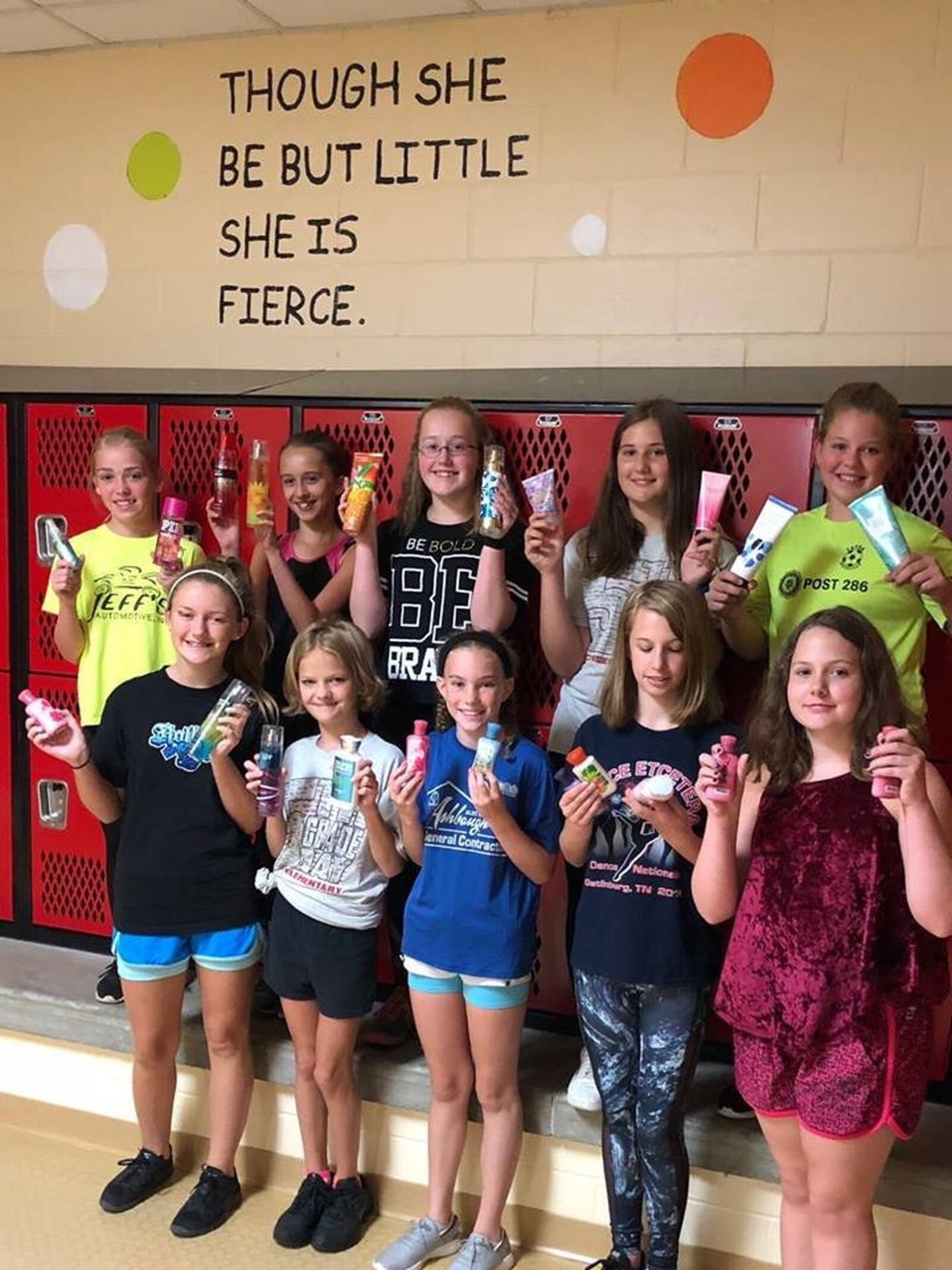 Tecumseh Middle School girls hold bottles of lotions and perfumes that were donated to them by community members after their gym teacher, Sheli Randall asked for donations via Facebook. Randall said she’s received over 300 bottles so far. CONTRIBUTED.