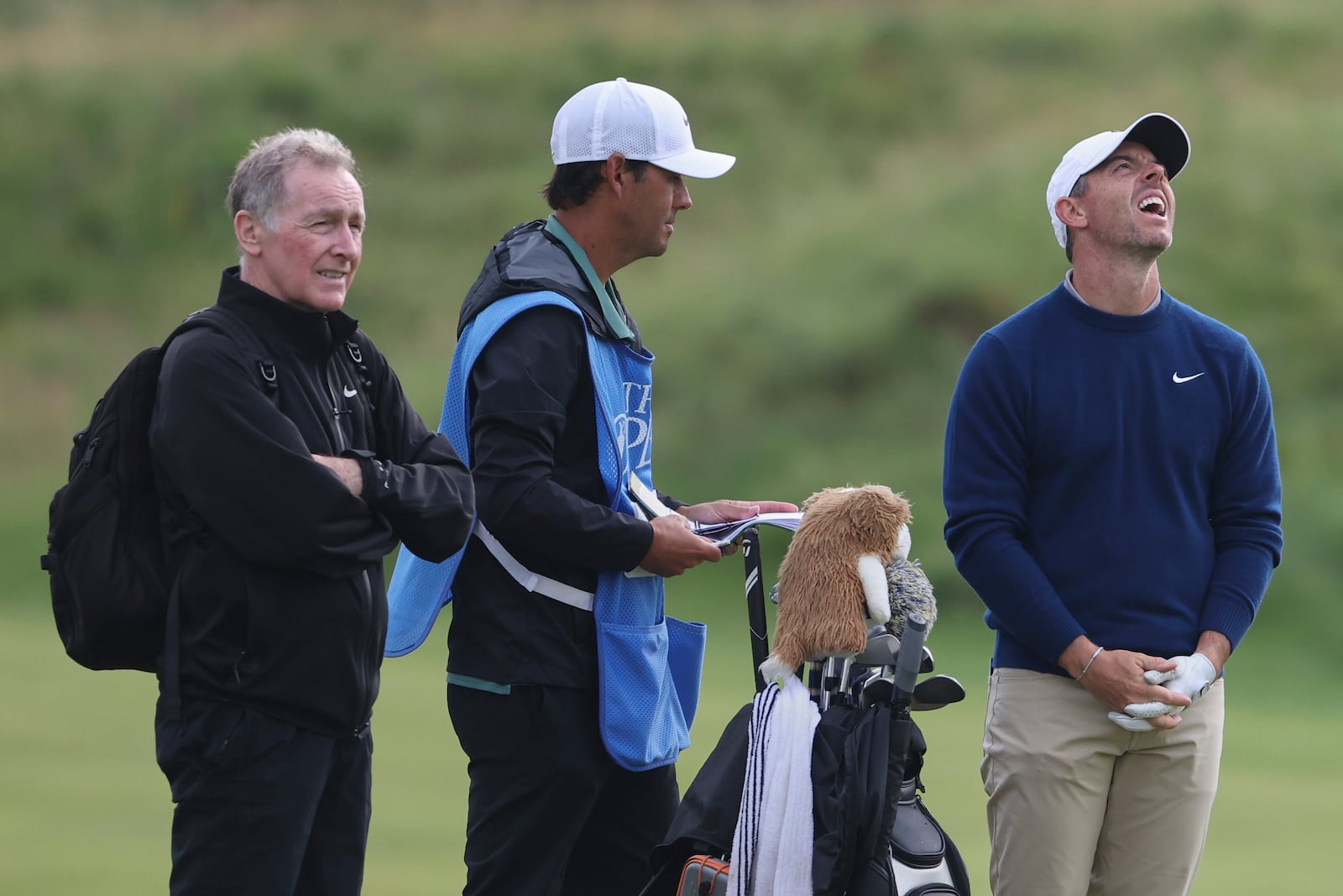 Rory McIlroy of Northern Ireland, right laughs, with caddy Harry Diamond, center, on the 11th fairway during a practice round for the 2025 British Open golf championship at the Royal Portrush Golf Club, Northern Ireland, Monday, July 14, 2025. (AP Photo/Peter Morrison)