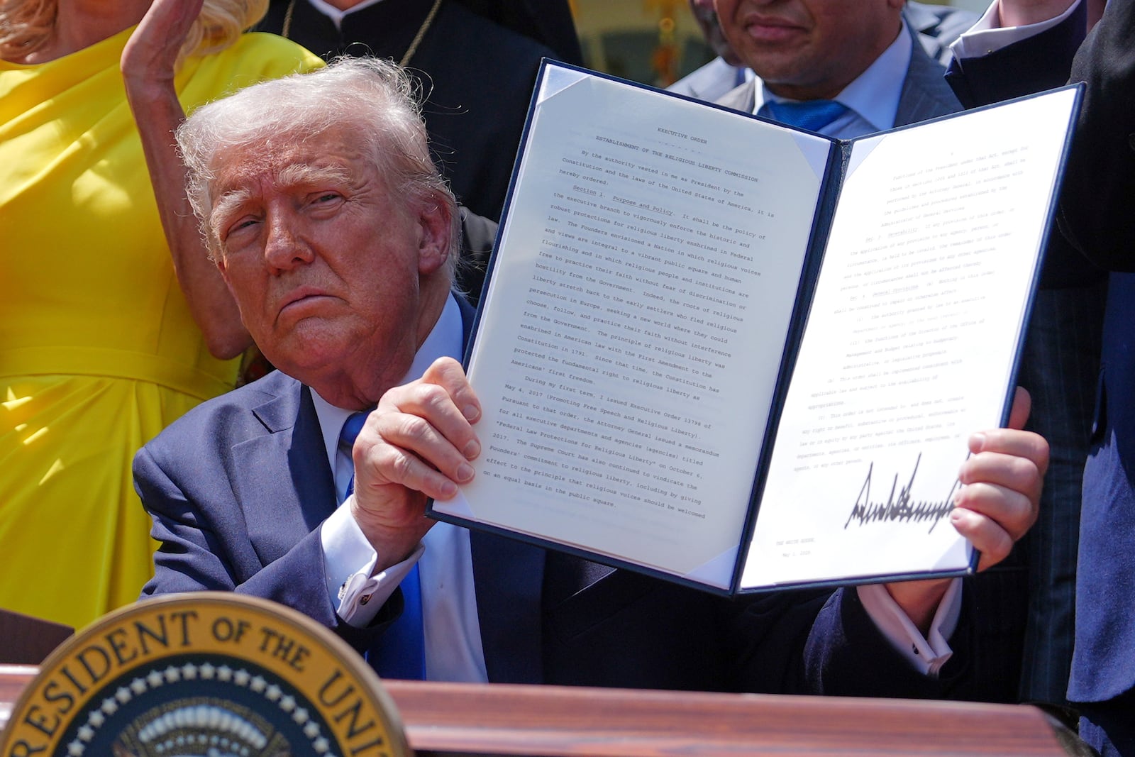 President Donald Trump holds up a signed executive order establishing the Religious Liberty Commission, during a National Day of Prayer event in the Rose Garden of the White House, Thursday, May 1, 2025, in Washington. (AP Photo/Evan Vucci)