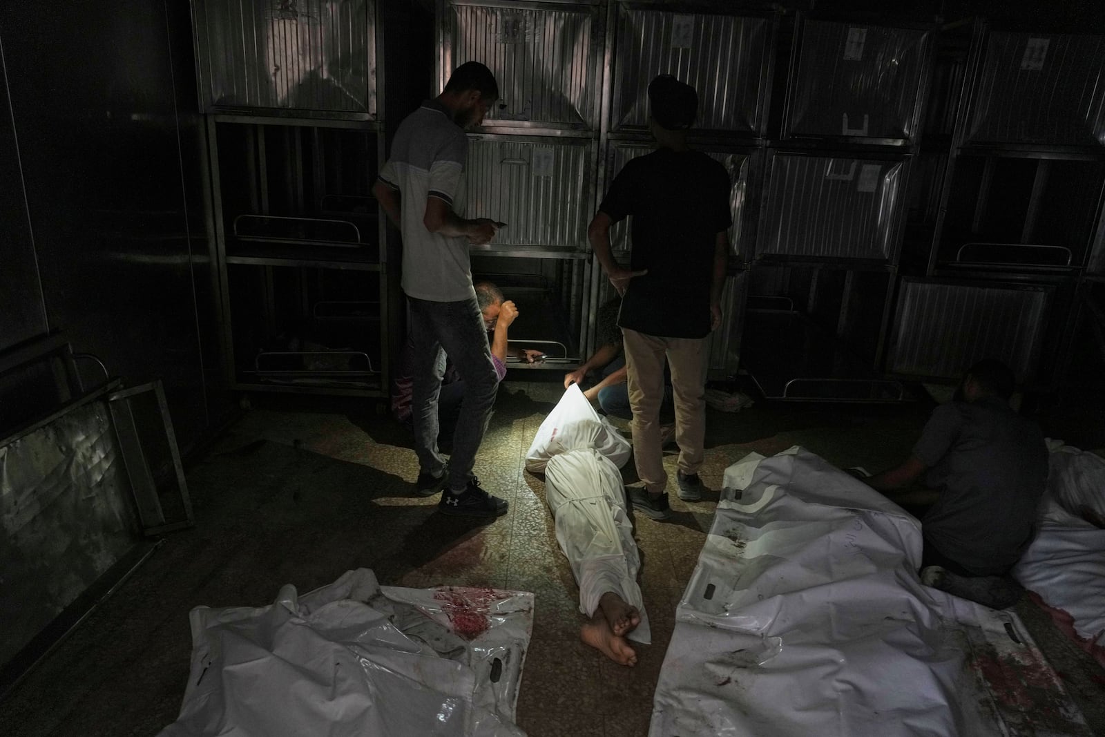 Palestinians mourn relatives killed in an Israeli army bombardment of Gaza at the morgue of Shifa Hospital in Gaza City Tuesday, July 22, 2025. (AP Photo/Jehad Alshrafi)