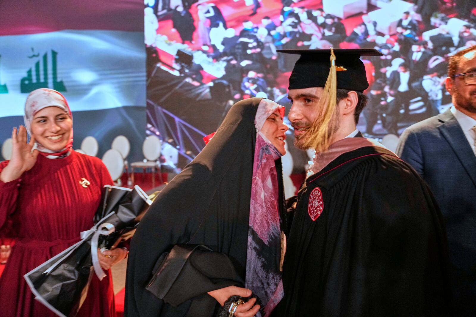 An Iraqi mother celebrates with her son during the first graduation for The American University of Iraq - Baghdad in Baghdad, Iraq, Saturday, May 24, 2025. (AP Photo/Hadi Mizban)