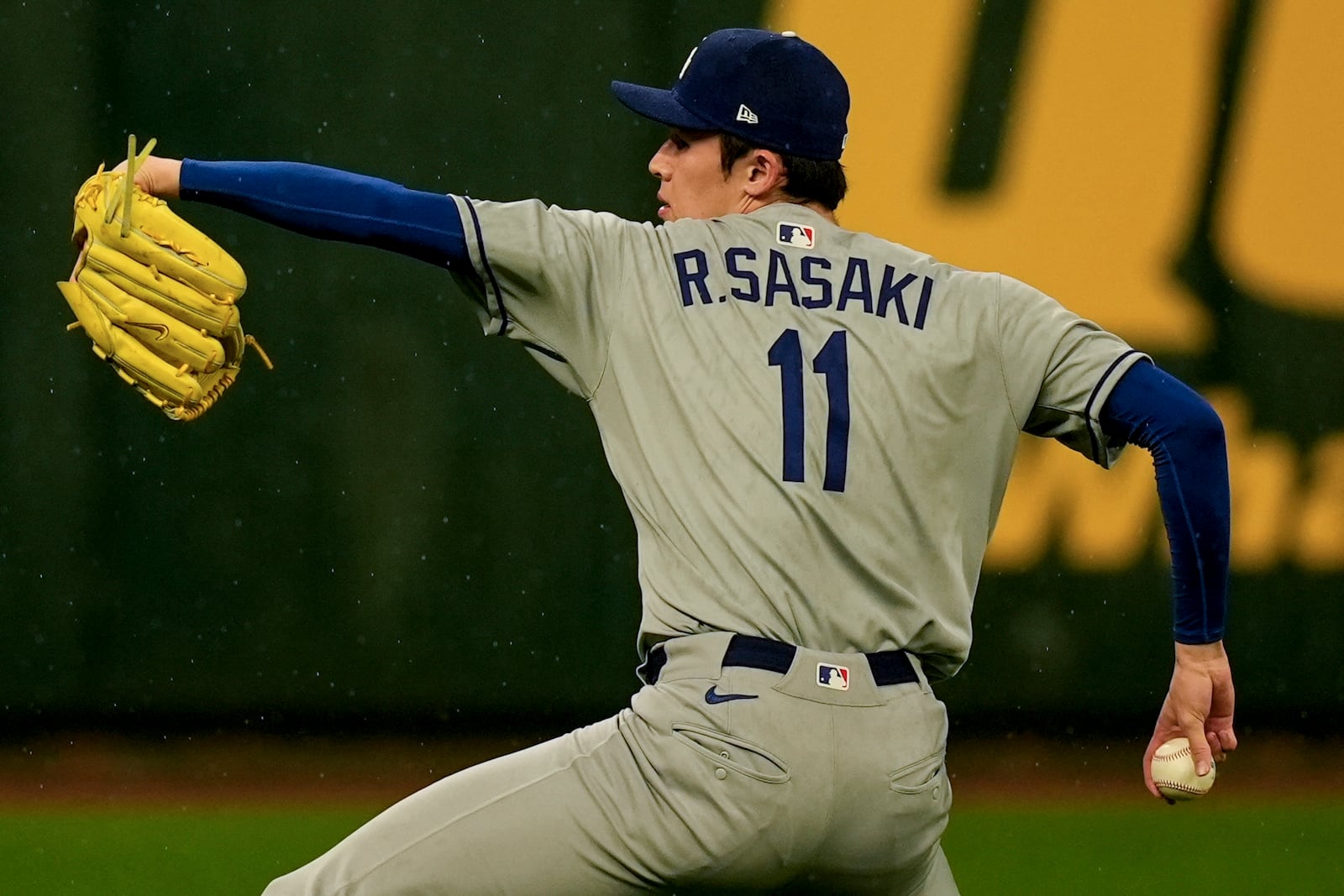 Los Angeles Dodgers pitcher Roki Sasaki warms up in the rain ahead of a baseball game between the Atlanta Braves and the Los Angeles Dodgers, Saturday, May 3, 2025, in Atlanta. (AP Photo/Mike Stewart)