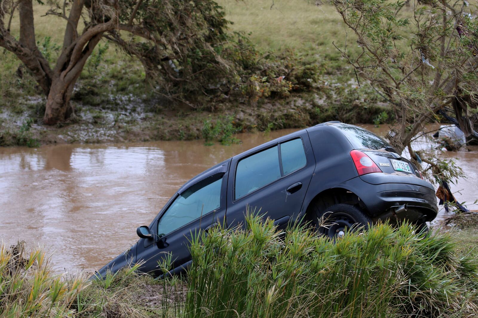 A view of a vehicle abandoned in a flooded area, in Mthatha, South Africa, Wednesday, June 11, 2025. (AP Photo/Hoseya Jubase)