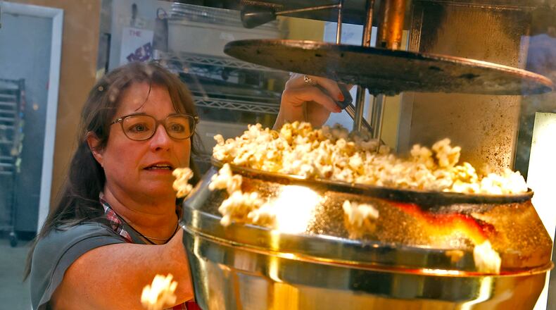 Kathy Brougher, an employee of The Peanut Shoppe, makes fresh popcorn for a customer Tuesday, Nov. 21, 2023. BILL LACKEY/STAFF