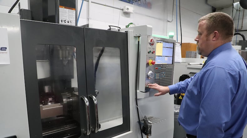 Jason Chilman, an instructor in the engineering department at Clark State Community College, demontrates the college’s new 5 axis milling machine in the manufacturing lab in 2019. BILL LACKEY/STAFF