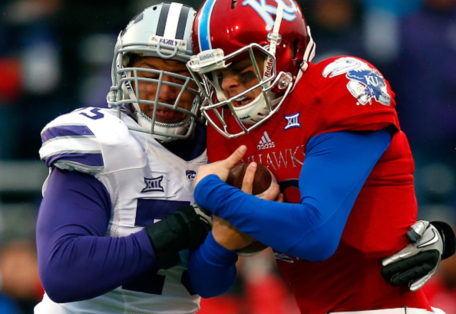 LAWRENCE, KS - NOVEMBER 28: Quarterback Ryan Willis #13 of the Kansas Jayhawks is sacked by defensive end Jordan Willis #75 of the Kansas State Wildcats during the game at Memorial Stadium on November 28, 2015 in Lawrence, Kansas. (Photo by Jamie Squire/Getty Images)