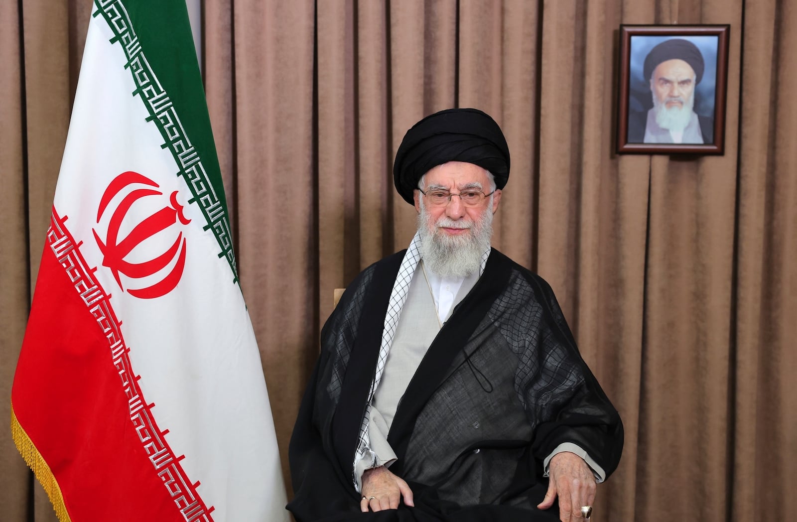 This photo released by an official website of the office of the Iranian supreme leader, shows Supreme Leader Ayatollah Ali Khamenei in a televised speech, under a portrait of the late revolutionary founder Ayatollah Khomeini, Friday, June 13, 2025. (Office of the Iranian Supreme Leader via AP)