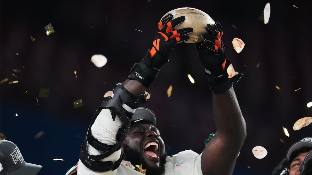 Miami offensive lineman Markel Bell holds up a trophy after winning the Fiesta Bowl NCAA college football playoff semifinal game against Mississippi, Thursday, Jan. 8, 2026, in Glendale, Ariz. (AP Photo/Ross D. Franklin)