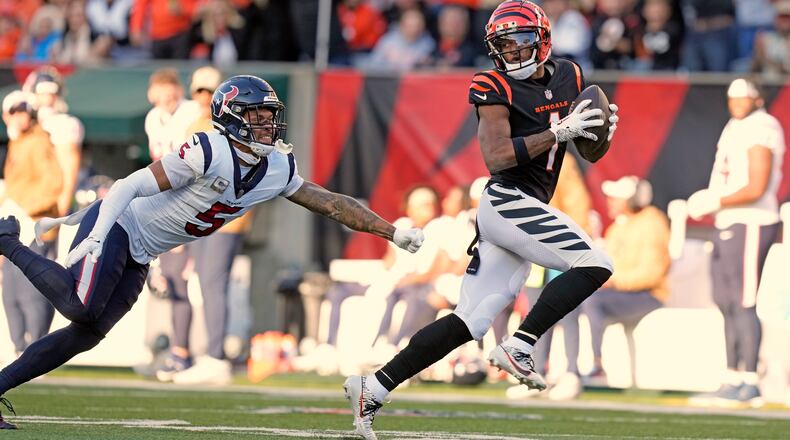 Cincinnati Bengals wide receiver Ja'Marr Chase (1) looks back at Houston Texans safety Jalen Pitre (5) while making a catch and run for a 64-yard touchdown during the second half of an NFL football game Sunday, Nov. 12, 2023, in Cincinnati. (AP Photo/Carolyn Kaster)