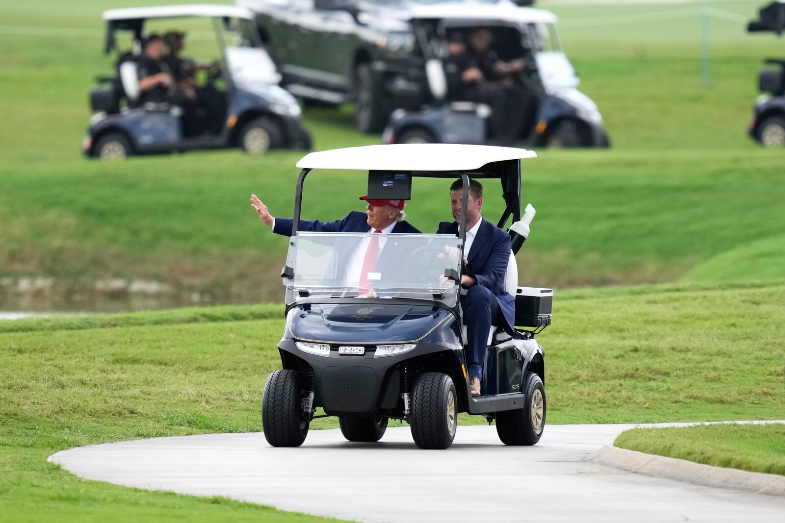 President Donald Trump, driven by his son Eric Trump, arrives at Trump National Doral during the LIV Golf Miami tournament, Thursday, April 3, 2025, in Miami. (AP Photo/Alex Brandon)
