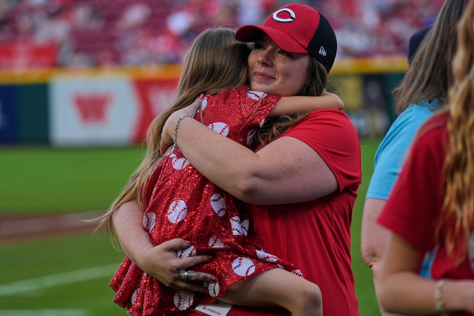 Pete Rose's daughter Cara Rose hugs Rose's granddaughter Jolie during Pete Rose Night events before a baseball game between the Cincinnati Reds and the Chicago White Sox, Wednesday, May 14, 2025, in Cincinnati. (AP Photo/Carolyn Kaster)