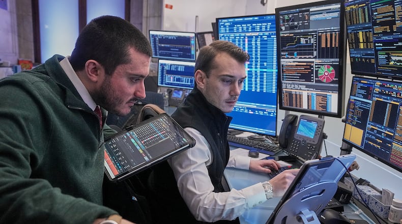 Traders Drew Cohen, left, and Dylan Halvorsan work on the floor of the New York Stock Exchange, Monday, Jan. 26, 2026. (AP Photo/Richard Drew)