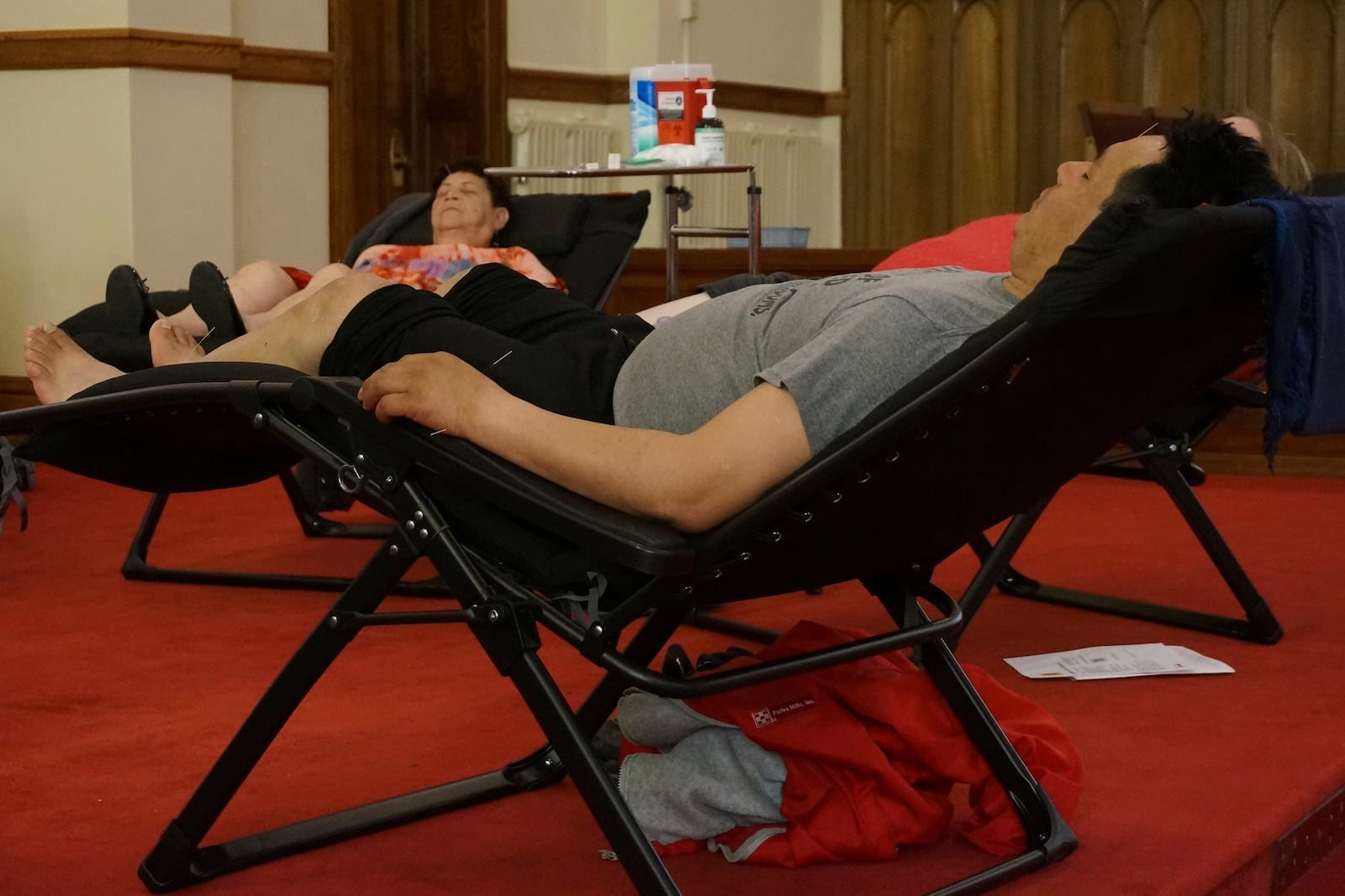 Juan Carlos Toapanta, foreground, and Martha Dominguez, background, receive acupuncture treatments in the sanctuary of St. Paul’s-San Pablo Lutheran Church, which recently added wellness sessions as part of its migrant ministry, in Minneapolis, Sunday, April 27, 2025. (AP Photo/Giovanna Dell’Orto)