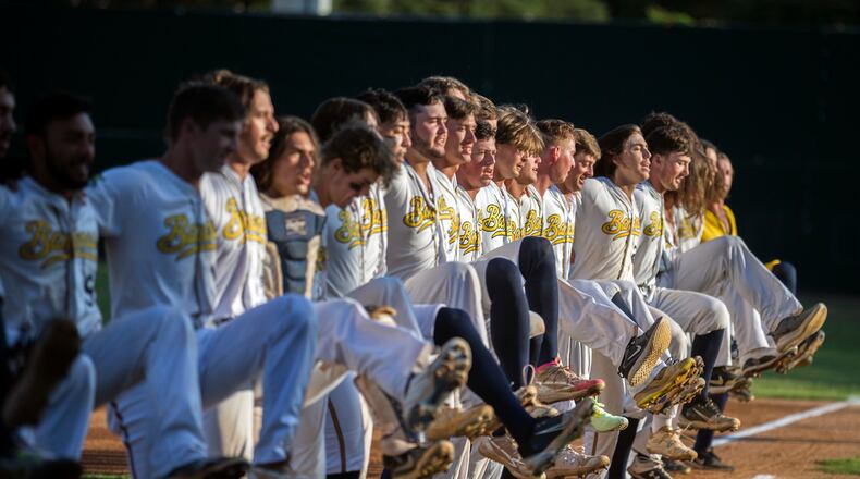 FILE- The Savannah Bananas line up along the first base line to perform a kick-line dance before a Coastal Plain League baseball game against the Florence Flamingos, June 7, 2022, in Savannah, Ga. (AP Photo/Stephen B. Morton, File)