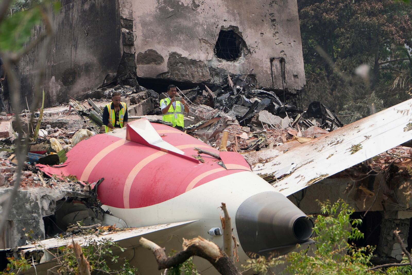 Officials inspect the site of Thursday's Air India plane crash on the roof of a building in Ahmedabad, India, Friday, June 13, 2025. (AP Photo/Ajit Solanki)