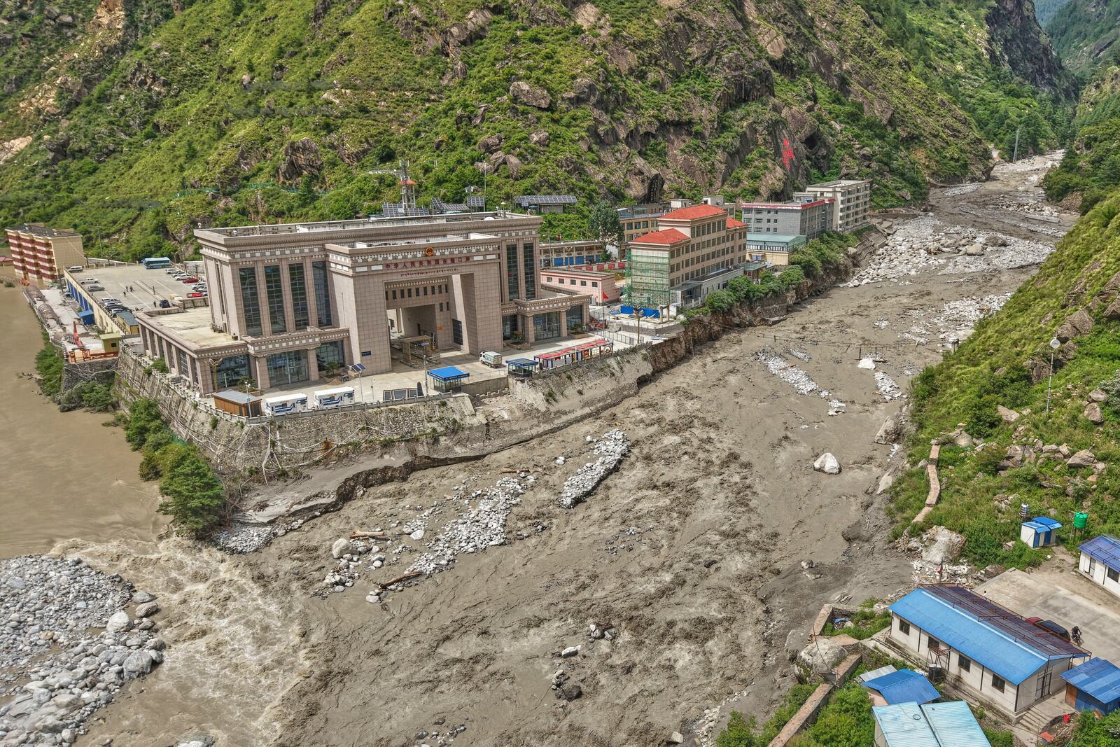 Chinese land on left, and Nepalese land on right are seen after Friendship bridge, a key bridge over the Bhotekoshi River connecting Nepal with China was swept away in monsoon rain at Rasuwagadi, 120 kilometers (75 miles) north of the capital, Kathmandu, Nepal, Wednesday, July, 9, 2025. (AP Photo/Sujan Gurung)