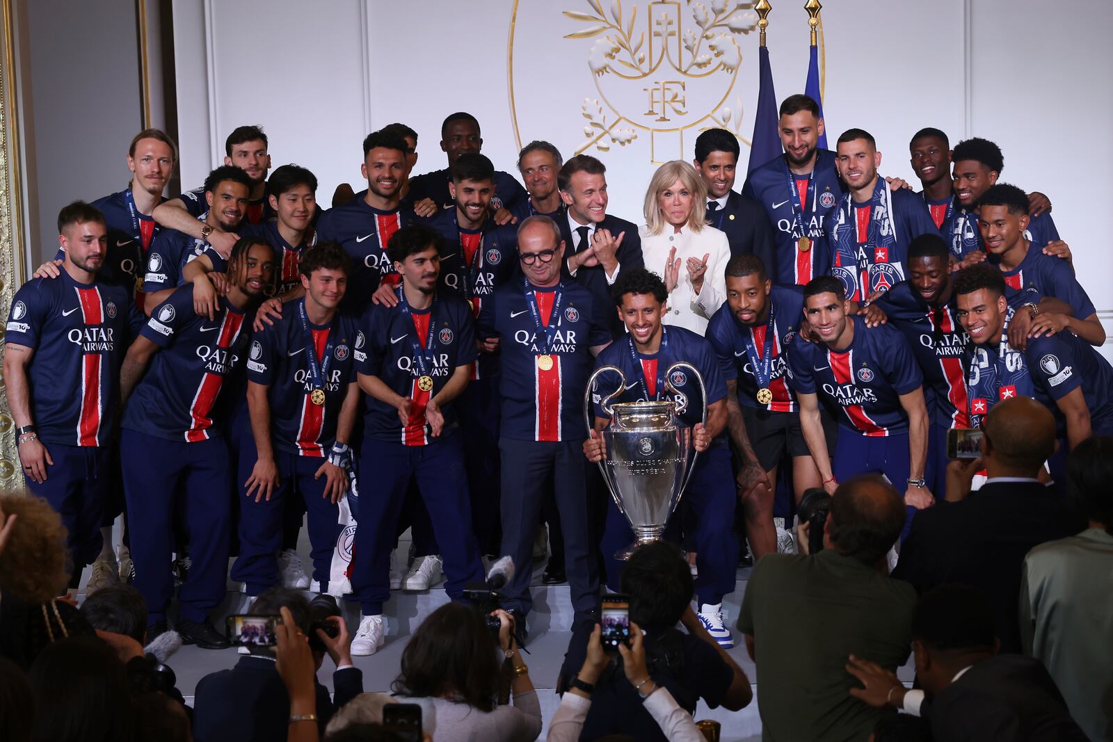 French President Emmanuel Macron, center left, his wife Brigitte Macron, pose with the PSG team after the team won the Champions League final soccer match between Paris Saint-Germain and Inter Milan Sunday, June 1, 2025 at the Elysee Palace in Paris. (AP Photo/Thomas Padilla, Pool)