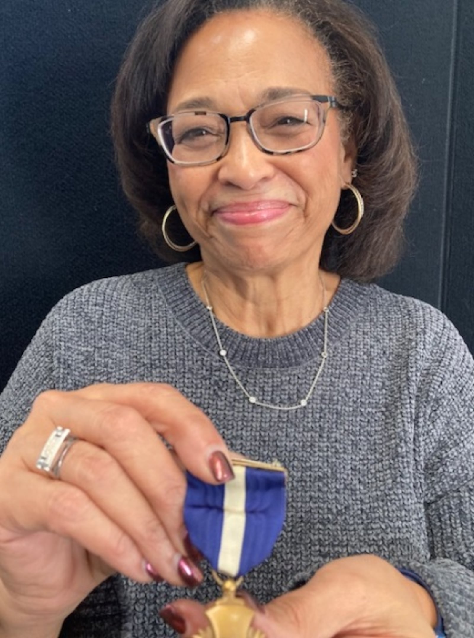 Kelley Neal Gray holds the Navy Cross her father, George Neal, was awarded for heroism in the Korean War. CONTRIBUTED