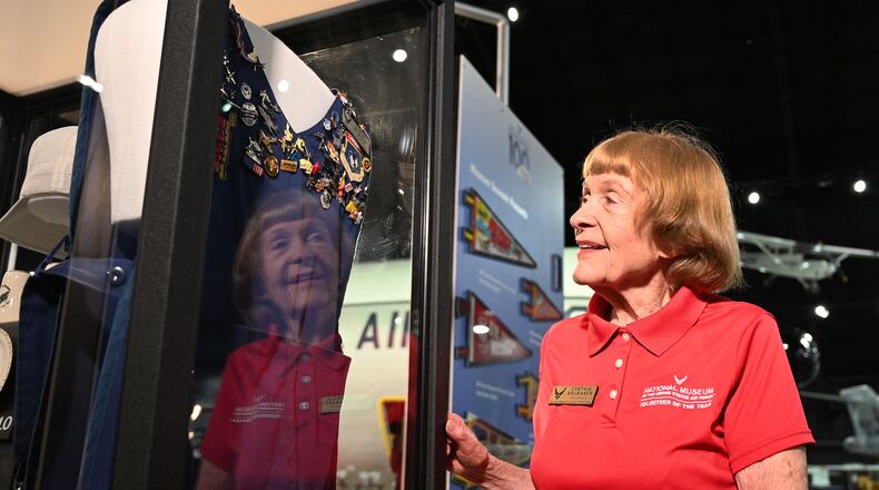 Cynthia Brubaker views her collection of aviation souvenir pins that is on display at the National Museum of the US Air Force Centennial Exhibit. She was recently honored for 50 years of volunteer service to the museum.