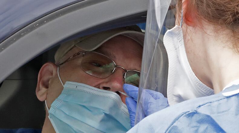 Tom Nash gets a COVID-19 test Wednesday as he sits in his van in the Burnett Plaza parking lot during the Clark County Combined Health District's free COVID-19 testing clinic. This was the third free clinic the Health District has held but the first drive thru clinic. BILL LACKEY/STAFF