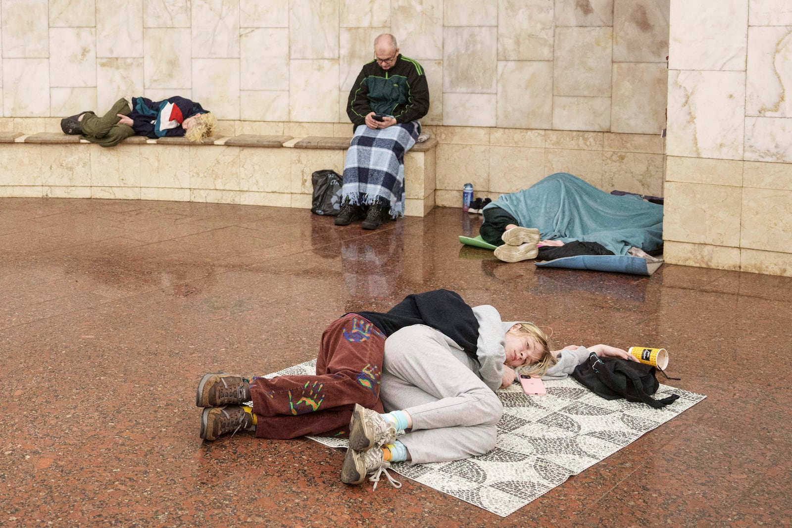 Couple sleep on a floor as they take cover at a metro station during a Russian drone strike on Kyiv, Ukraine, Tuesday, June 10, 2025. (AP Photo/Evgeniy Maloletka)