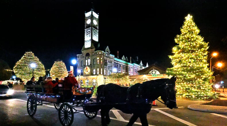 A horse drawn carriage is pictured among the bright holiday lights of last year's Holiday in the City events. Donations for Springfield's shelters will be accepted during Holiday in the City on Friday outside of COHatch. BILL LACKEY/STAFF