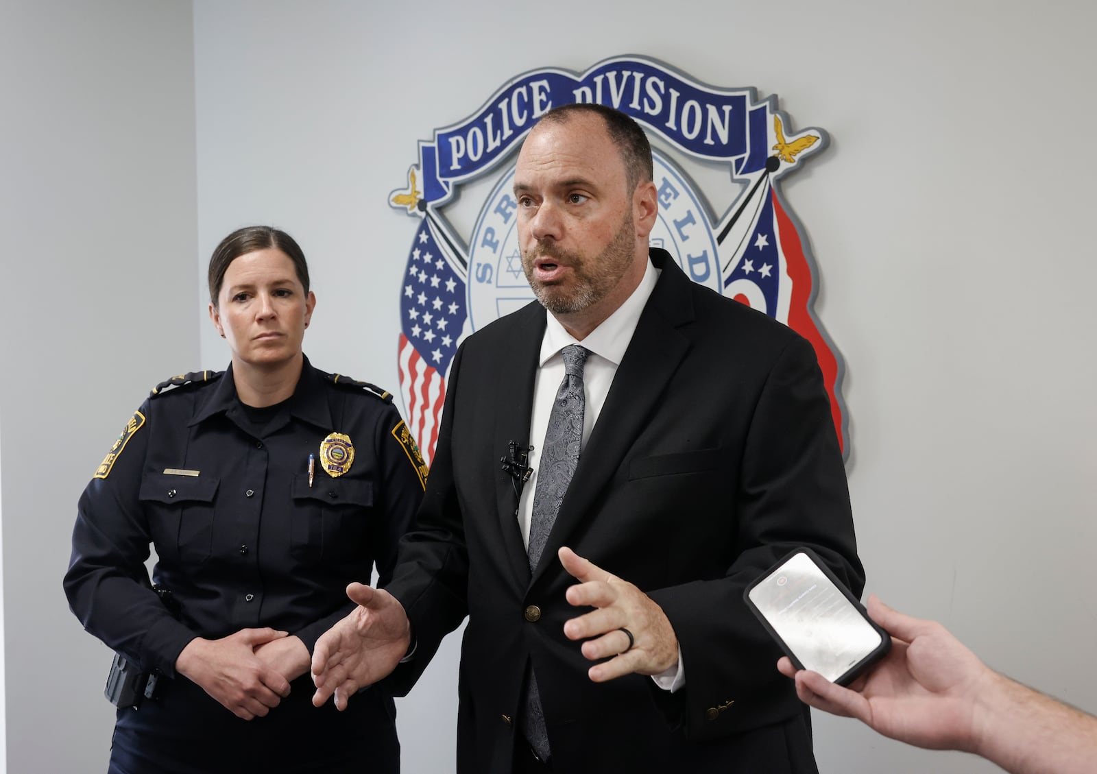 Springfield Police Chief Allison Elliott, left, listens as Springfield Police Sgt. James Byron speaks at a press conference on Friday, May 16, 2025, about three shootings that resulted in two homicides. JOSEPH COOKE/STAFF