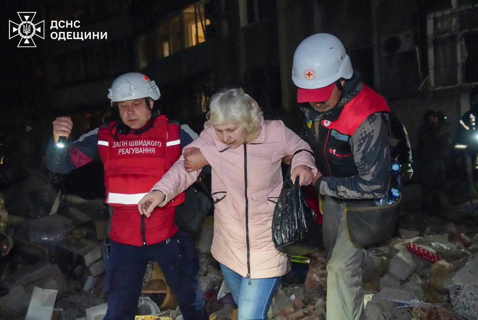 In this photo provided by the Ukrainian Emergency Service, rescuers help evacuate an elderly resident from her damaged house following Russia's air raid in Odesa, Ukraine, Thursday, May 1, 2025. (Ukrainian Emergency Service via AP)