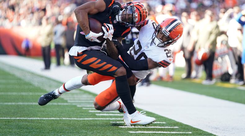 Cincinnati Bengals' Ja'Marr Chase (1) is tackled by Cleveland Browns' Greg Newsome II (20) during the second half of an NFL football game, Sunday, Nov. 7, 2021, in Cincinnati. (AP Photo/Bryan Woolston)